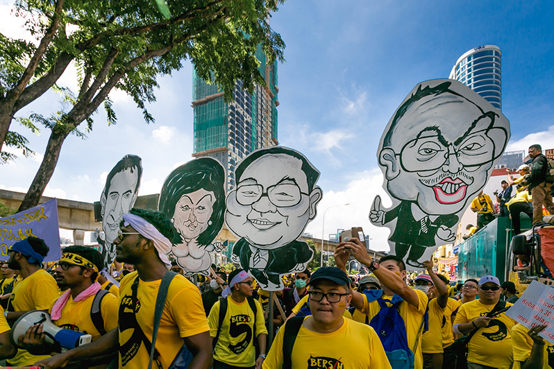 BERSIH 2.0 Protesters hold placards with caracature depicting Najib Razak, Rosmah Mansur, Jho Low.