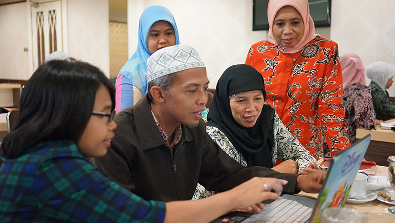 people gather around computer 